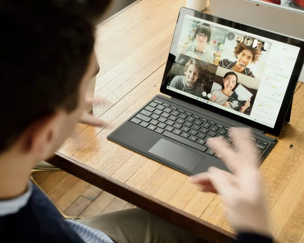 Deelnemer volgt het hybride event op zijn laptop, met de andere kijkers in beeld.