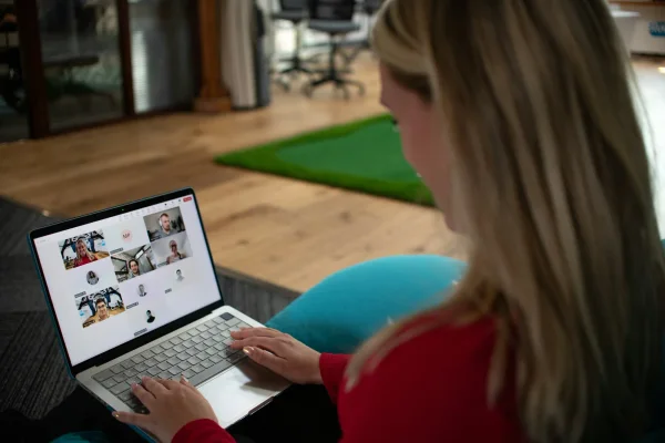 Kijker volgt de uitzending vanaf een zitzak, met de online deelnemers op haar laptopscherm.