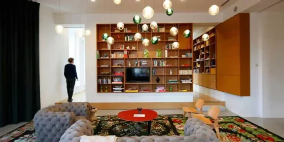 Loungeruimte met boekenkast, televisie en zitbanken.