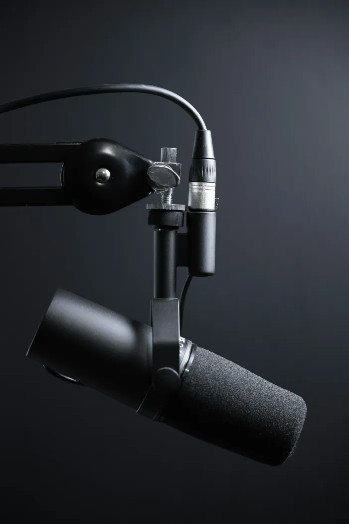 Podcastmicrofoon in een shockmount met aangesloten kabels.