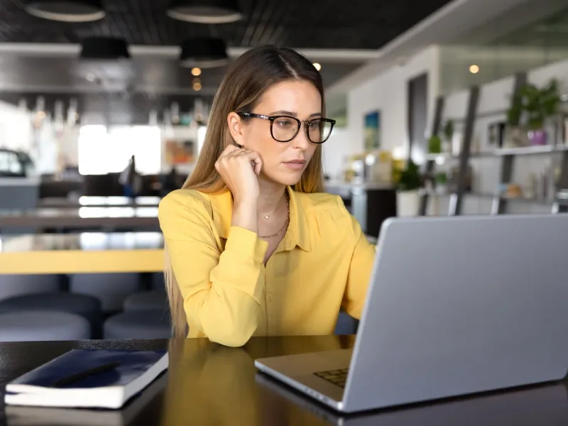 Medewerker volgt de lancering op haar laptop vanaf een werkplek in een kantoortuin.