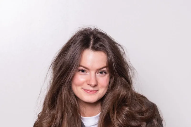 Shanou, projectmanager bij Livestream Solutions, kijkt glimlachend in de camera.